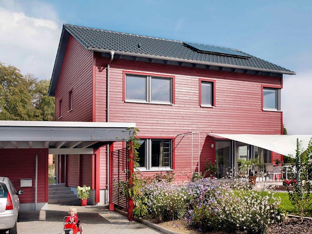 Einfamilienhaus E 20-148.6 von SchwörerHaus mit roter Fassade und Satteldach — Fertighaus mit 137 m²
